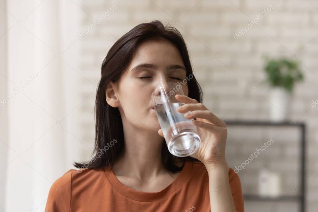 Close up attractive young woman enjoying fresh mineral water