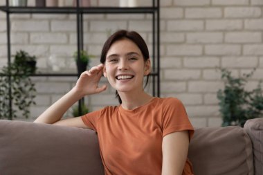 Çekici bir kadının portresi rahat bir kanepede oturuyor.