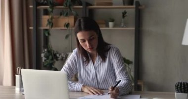 Gergin genç bir kadın stresli hissediyor, kağıtları havaya fırlatıyor..