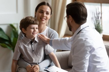 İlgilenen erkek çocuk doktoru küçük çocuk hastasına destek oluyor.