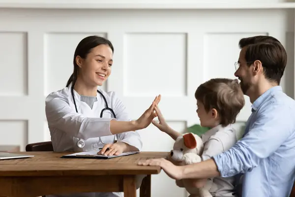 Feliz saludo médico femenino con un pequeño paciente —  Fotos de Stock