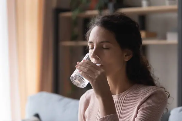 Happy young woman drinking glass of fresh pure mineral water. — Stock Photo, Image