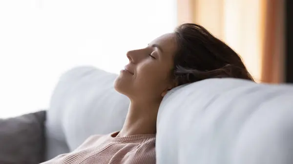 Wanita muda yang tenang tidur di sofa yang nyaman. — Stok Foto