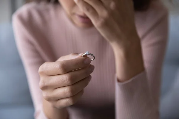 Frustrated millennial unhappy woman denied marriage, holding ring in hand.