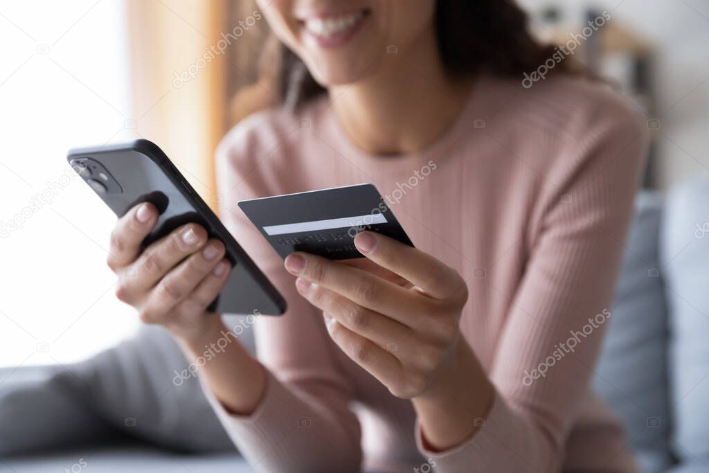 Close up smiling millennial woman holding smartphone and credit card.