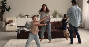 Evli ve çocuklu çift oturma odasında dans ediyor.
