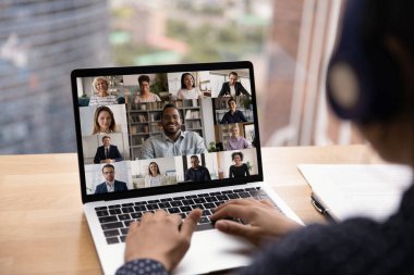 Kulaklıklı kadın laptop kullanılarak video konferansına katılıyor