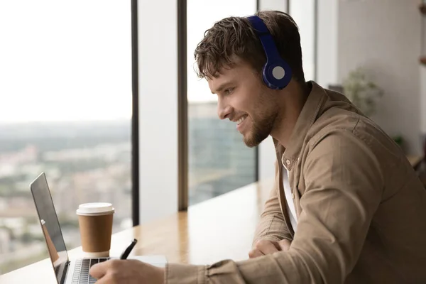 Young male translator in headphones engaged in video remote interpreting — Stock Photo, Image