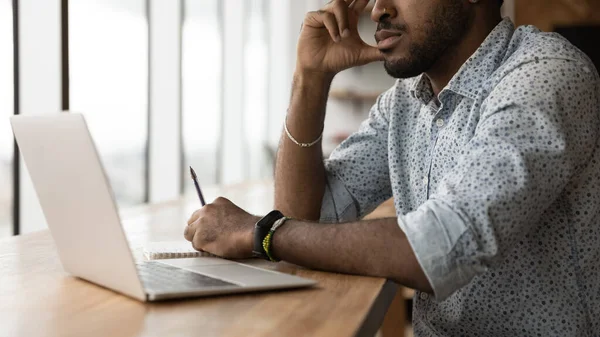 Pensativo joven negro sentarse en el escritorio antes de la pantalla de la PC —  Fotos de Stock