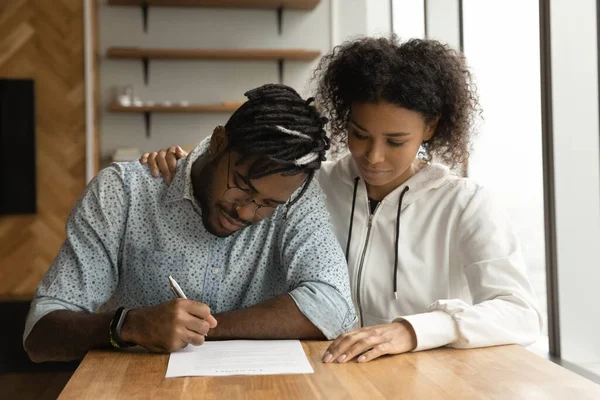 聚焦的年轻黑人夫妇在律师事务所签署婚前协议 — 图库照片