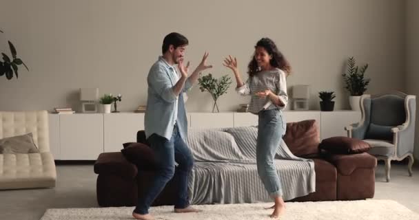 Feliz pareja divirtiéndose escuchar música bailando en la sala de estar — Vídeos de Stock