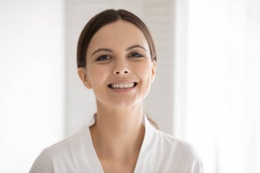 Bornozlu, gülümseyen beyaz kadın portresi.