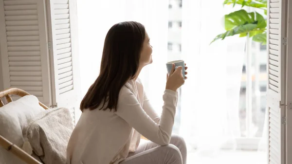 Femme heureuse se détendre dans la chaise à la maison boire du thé — Photo