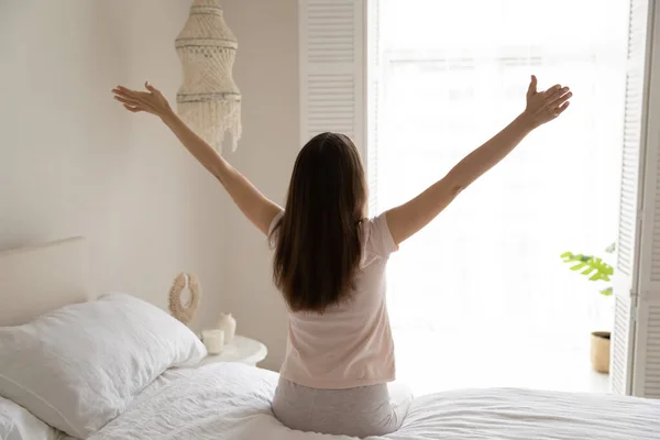 Back view of young woman stretch in bed at home — Stock Photo, Image