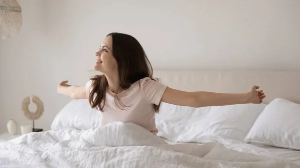 Wanita muda yang bahagia bangun di tempat tidur yang nyaman di rumah — Stok Foto