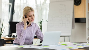 Genç bayan girişimci ofiste yalnız çalışıyor.