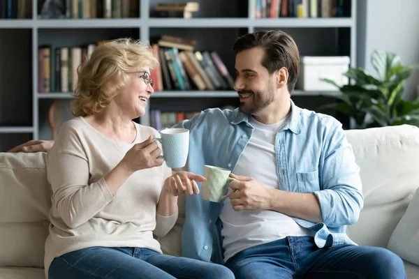 Smiling pleasant middle aged senior mother chatting with grown up son. — стоковое фото