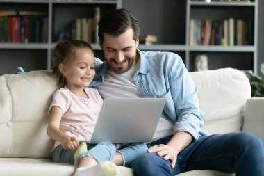 Happy bonding two generations family using computer at home.