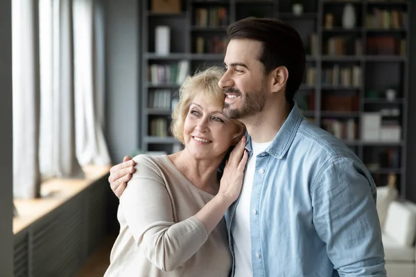 Happy dreamy affectionate bonding two generations family looking in distance. — Foto de Stock