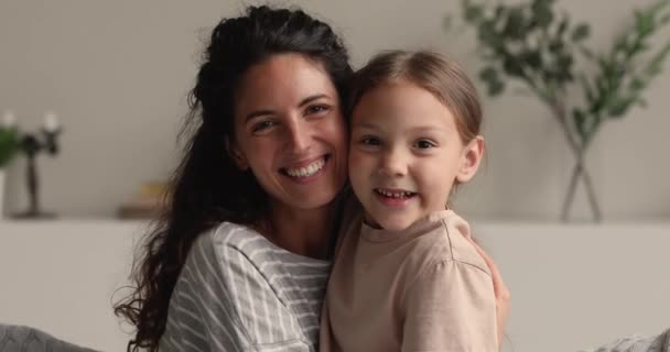 Jong mam haar kleine dochter knuffelen glimlachen kijken naar camera — Stockvideo