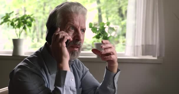 Heureux homme âgé retraité tenant un appel téléphonique mobile. — Video