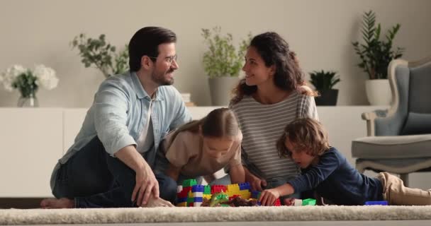 Familjen samlades i mysigt vardagsrum lek med små barn — Stockvideo