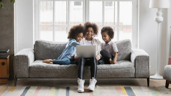 Heureuse femme afro-américaine avec des enfants utilisant un ordinateur portable à la maison — Photo