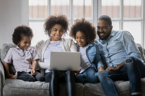 Close up happy African American family with kids using laptop