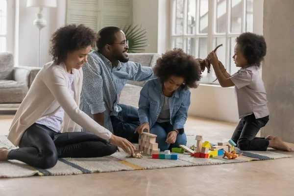 Feliz familia afroamericana jugando con juguetes en el suelo — Foto de Stock