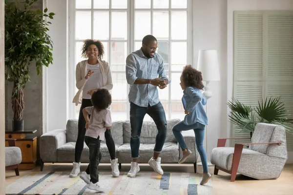 Pełna długość overjoyed Afroamerykanie rodzice i dzieci taniec — Zdjęcie stockowe
