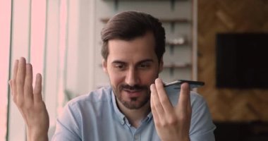 Neşeli gülümseyen genç adam sesli mesaj kaydediyor.