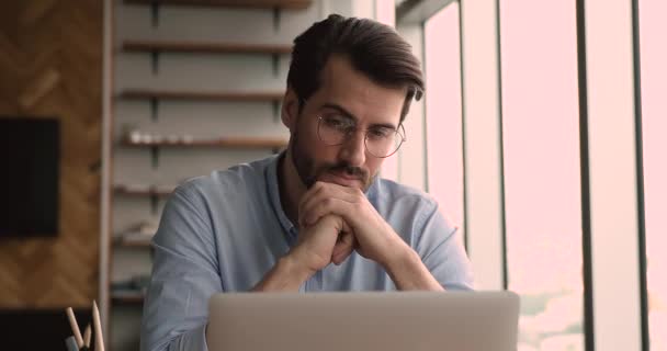 Fokussierter junger Geschäftsmann mit Brille, der am Computer arbeitet. — Stockvideo