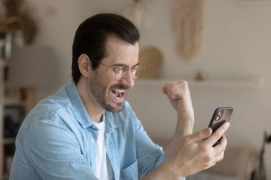 Milenyum adamı cep telefonu ekranından harika haberler okuyor.