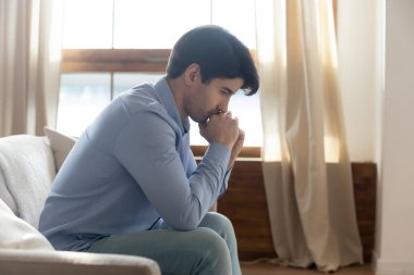 Düşüncelere dalmış, sorunlarla boğuşan sinirli bir adam.