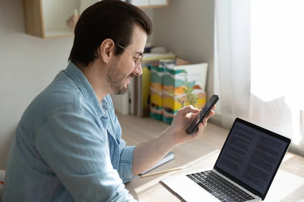 Young man sending files from cell to pc using app — Stock Photo, Image