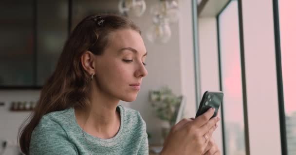 Sonriendo hermosa mujer milenaria mensaje de texto en el teléfono inteligente. — Vídeos de Stock