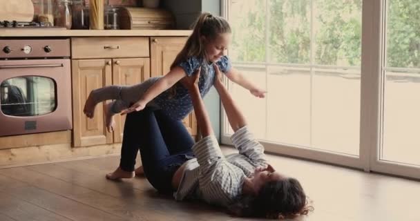 Jeune mère attentionnée jouant avion avec fille mignonne. — Video