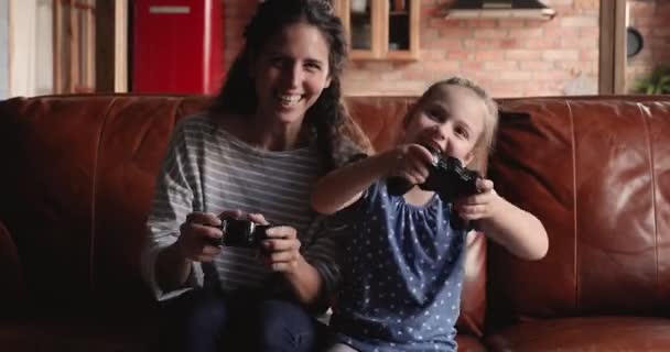 Gelukkig jong moeder spelen video games met weinig dochter. — Stockvideo