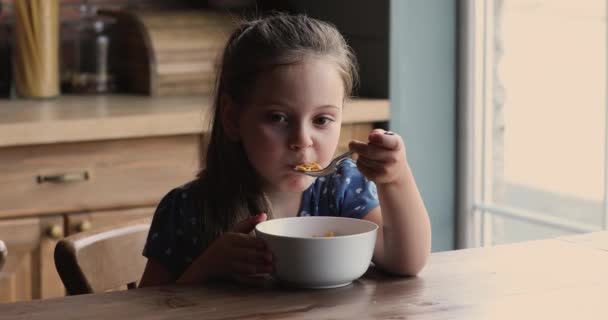 Gelukkig schattig klein meisje eten havermout met melk. — Stockvideo