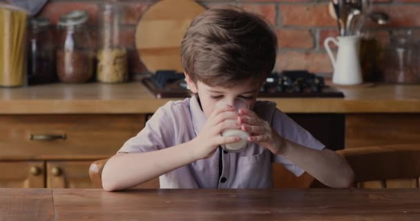 Liten söt pojke dricka mjölk eller yoghurt. — Stockvideo