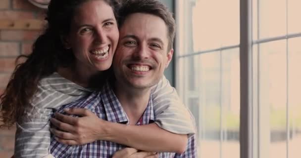 Feliz joven familia pareja mostrando cálidas relaciones en el interior. — Vídeos de Stock