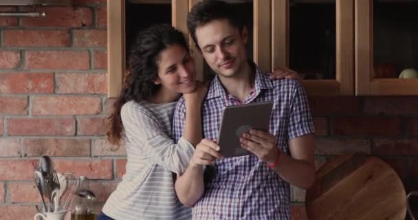 Счастливая тысячелетняя семейная пара, связавшая себя узами брака с помощью цифрового планшета. — стоковое видео