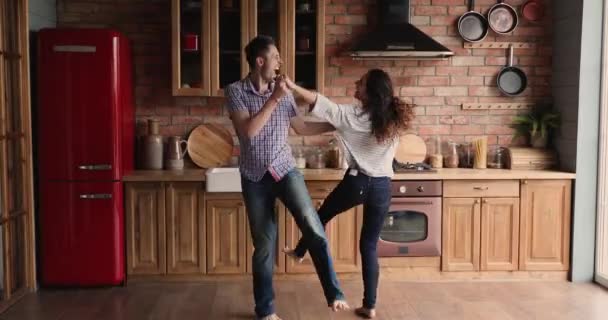 Overblij duizendjarige familie paar dansen in de keuken. — Stockvideo