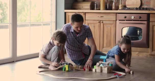 Fürsorglicher junger Vater spielt Spielzeug mit kleinen entzückenden Kindern. — Stockvideo