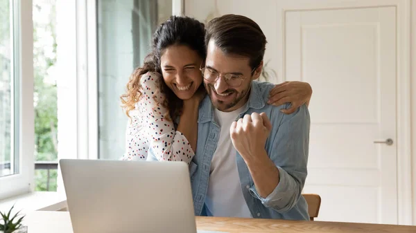 Laughing couple embracing by computer winning at sports betting — Stock Photo, Image