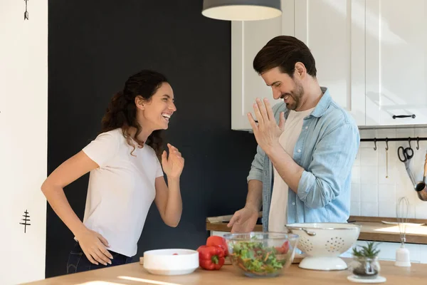 Actieve jonge echtgenoten dansen in de keuken rusten van koken voedsel — Stockfoto