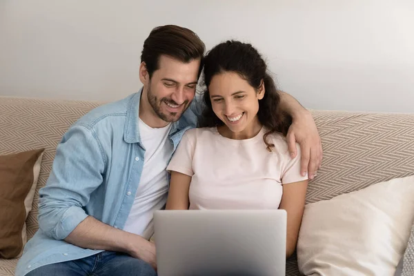 Amar a la pareja milenaria abrazando ver fotos familiares en PC juntos — Foto de Stock