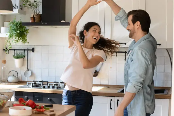 Восхитительная семейная пара с удовольствием танцует расслабляясь от приготовления пищи — стоковое фото