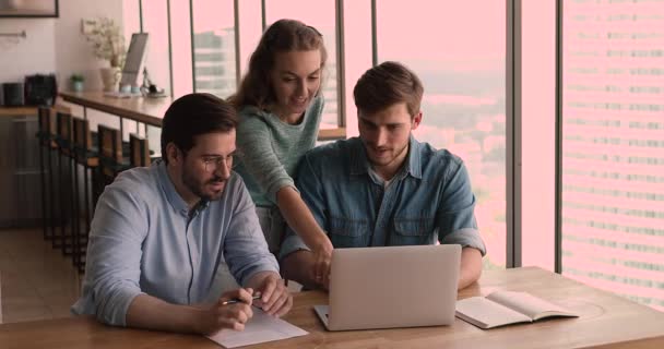 Lächelnde junge Mitarbeiterinnen diskutieren mit Kollegen über Online-Projektpräsentation. — Stockvideo