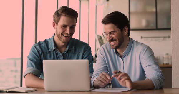 Modern ofiste bilgisayar üzerinde çalışan mutlu iki erkek arkadaş.. — Stok video
